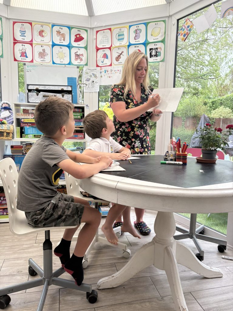 Tutor working with two children in Teatime Tutoring's Farnborough classroom